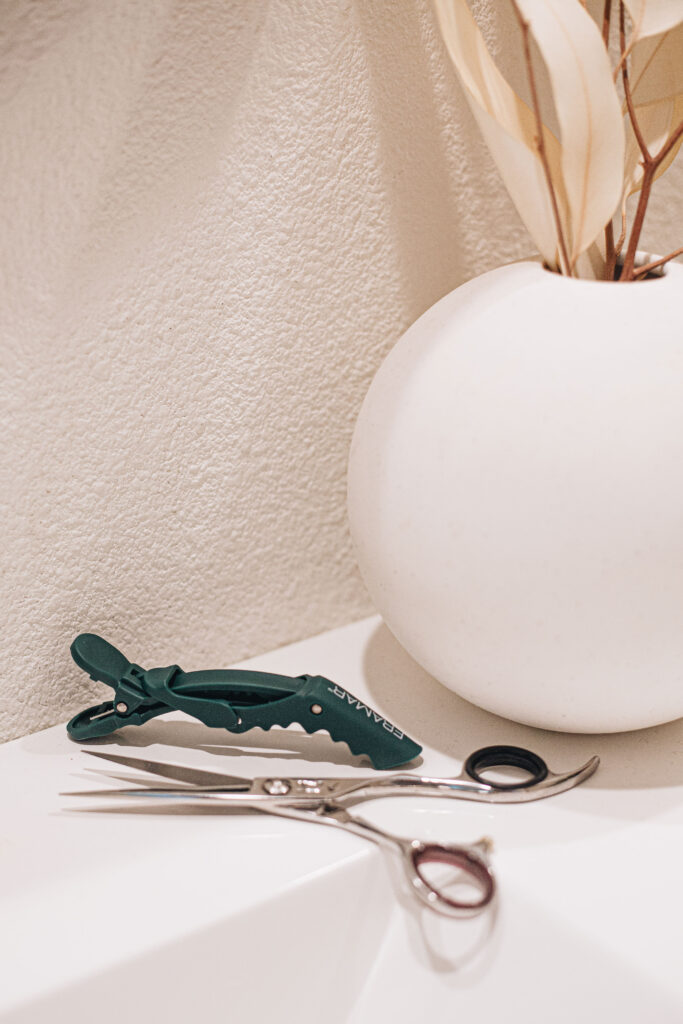 Professional hair cutting shears and clip on a salon counter in Ogden, Utah